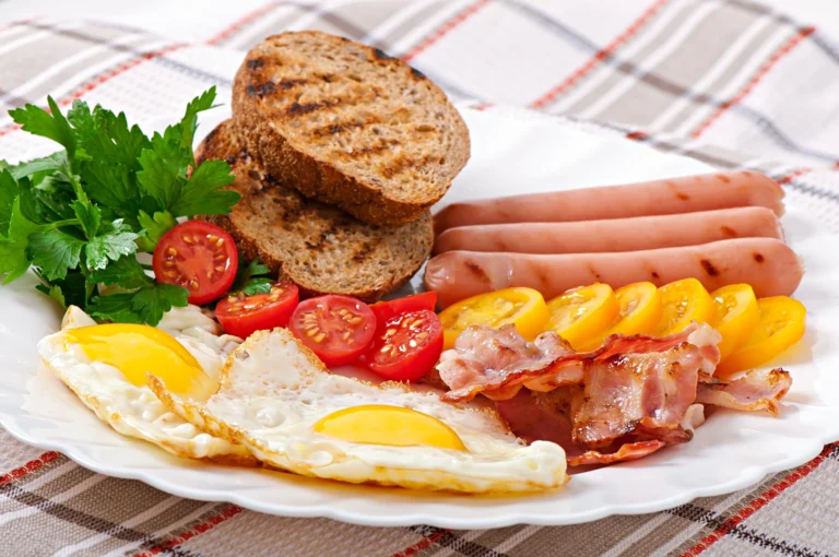 Close up of a fried egg on a full English breakfast plate with toast